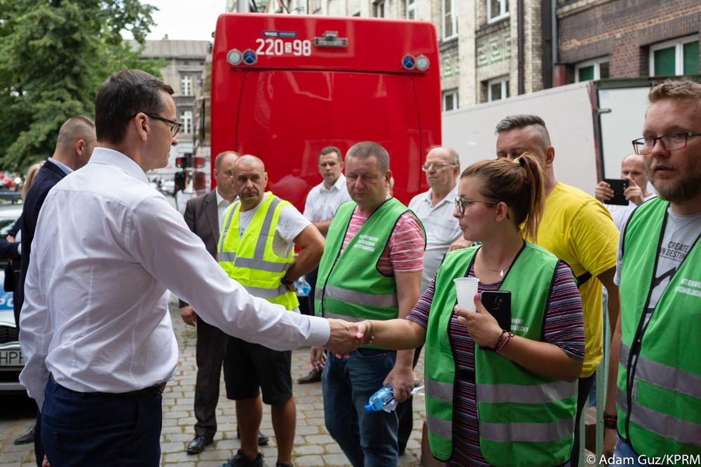 Premier Mateusz Morawiecki wita się z osobami będącymi na miejscu wybuchu kamienicy w Bytomiu.