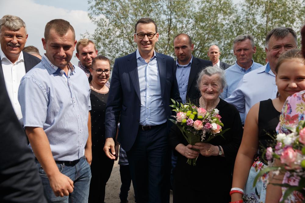 Premier Mateusz Morawiecki pozuje do zdjęcia z rolnikami.