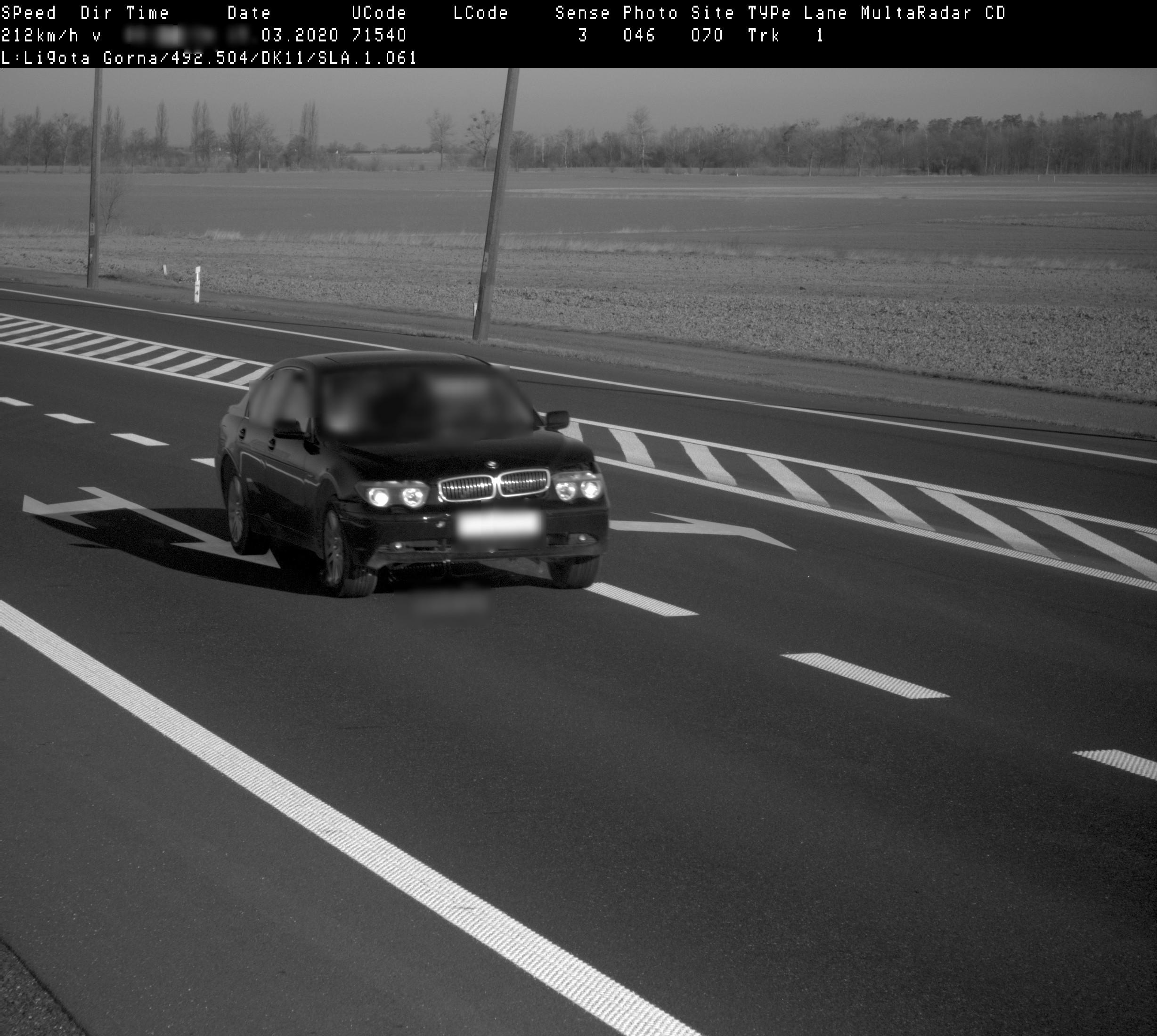 Zdjęcie z fotoradaru dokumentujące naruszenie prędkości przez pojazd osobowy. Samochód jedzie przez miejscowość Ligota Górna z prędkością 212 km/h.