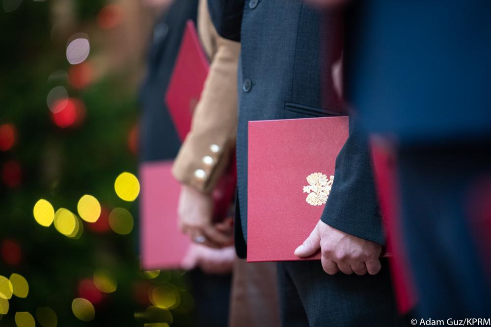 Funkcjonariusze trzymają teczki z nominacjami.