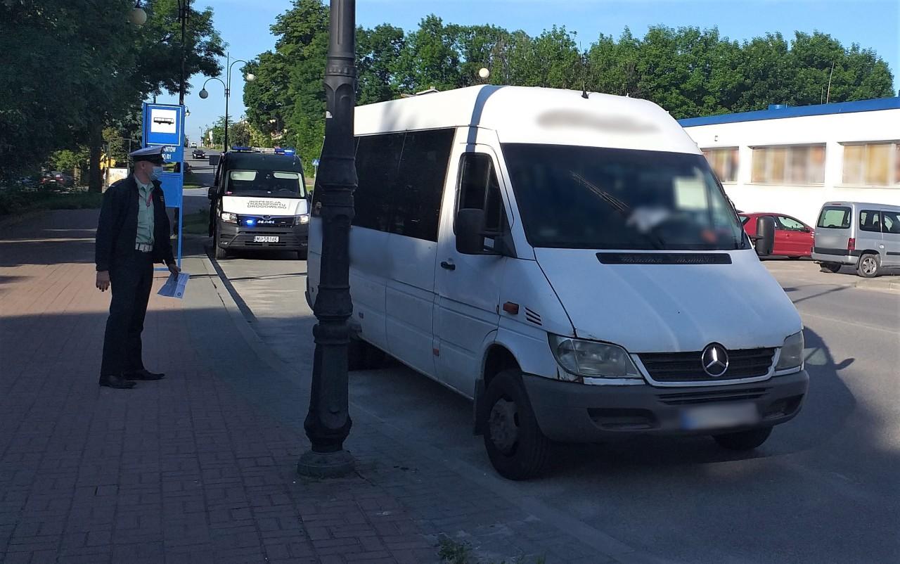 Inspektor świętokrzyskiej ITD stoi koło kontrolowanego autobusu.