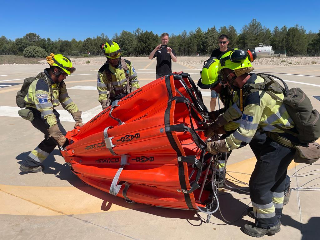 Grupa strażaków rozkłada zbiornik na wodę bambi-bucket , który zostanie podczepiony do helikoptera