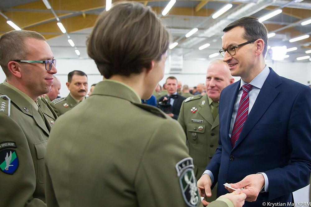 Premier Mateusz Morawiecki łamie się opłatkiem z żołnierzami.