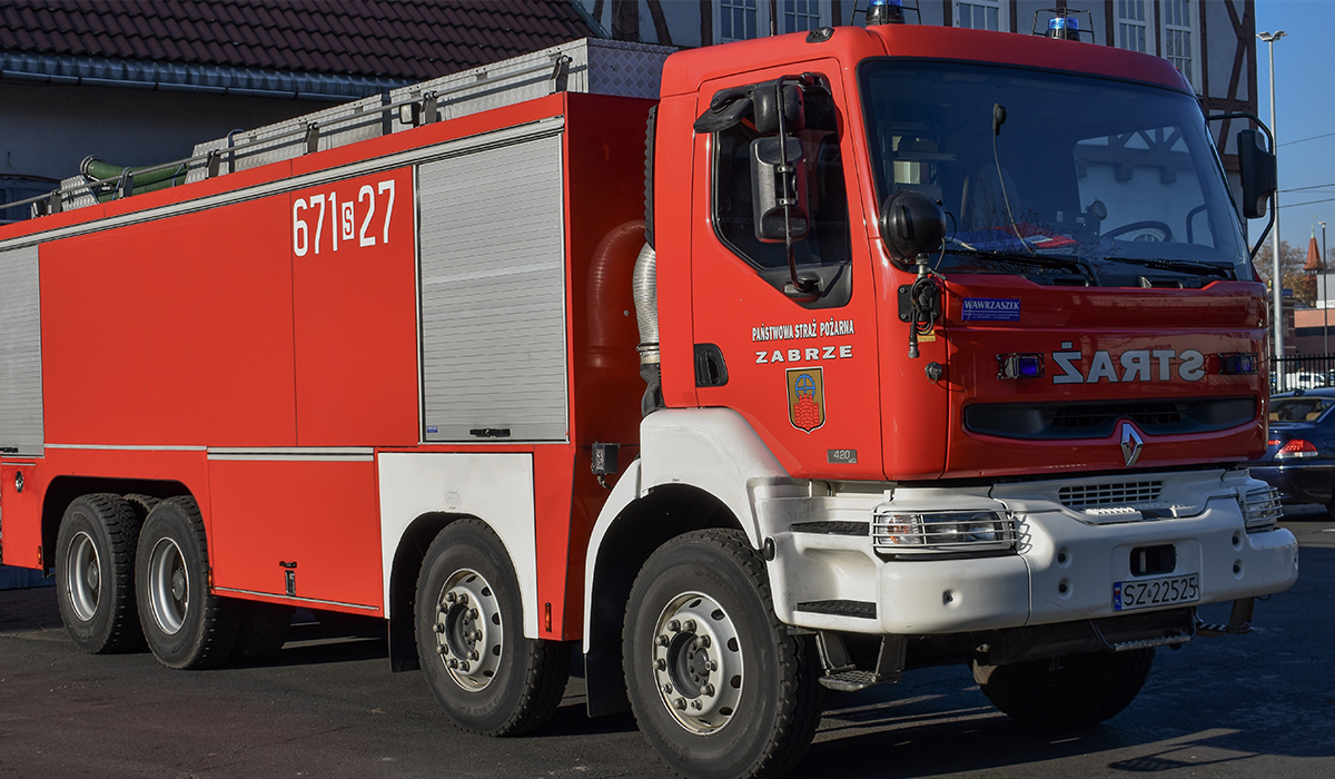 Zdjęcie przedstawia samochód ratowniczo-gaśniczy - ciężki Renault Kerax na tle budynku Komendy Miejskiej Państwowej Straży Pożarnej w Zabrzu