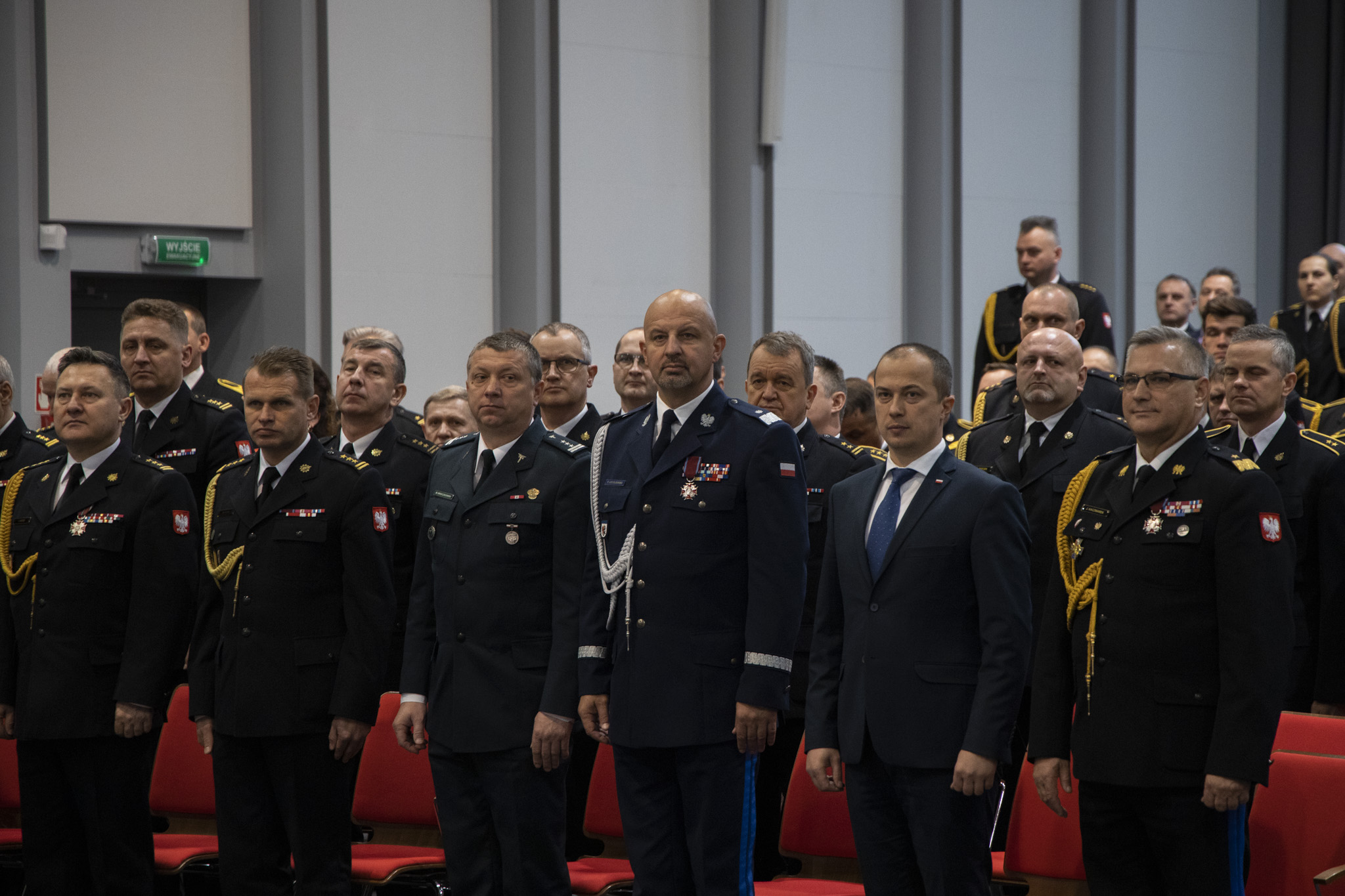 Widok na pierwszy rząd gości uroczystości - mundurowi w mundurach galowych, przedstawiciele róznych służb.