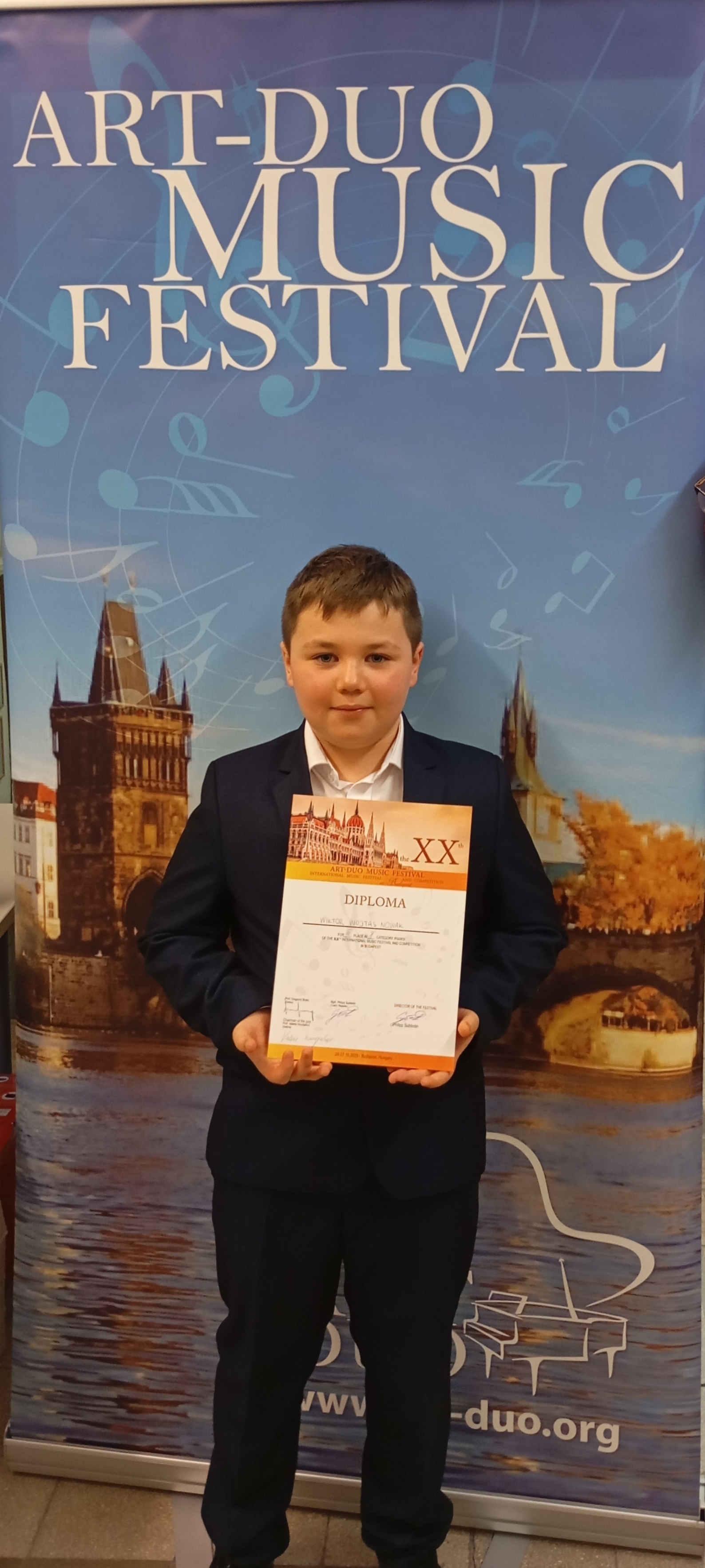 Wiktor Wojtas-Nowak Art Duo 2025. Uczeń na tle baneru konkursu.