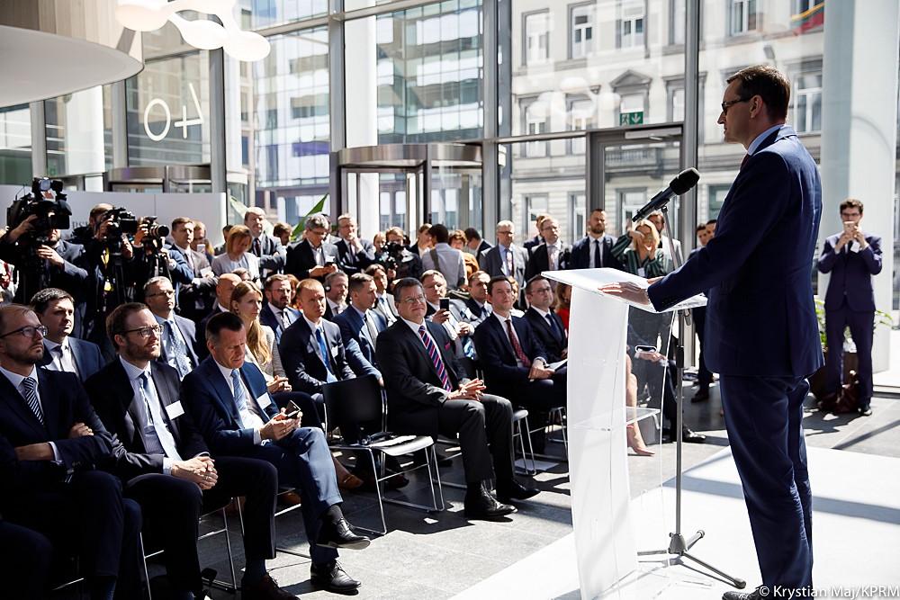 Premier Mateusz Morawiecki przemawia do siedzących naprzeciwko osób.