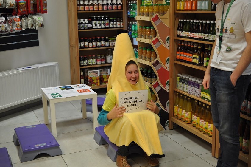 A girl dressed as a banana holds in her hands a card saying "I support fair trade".
