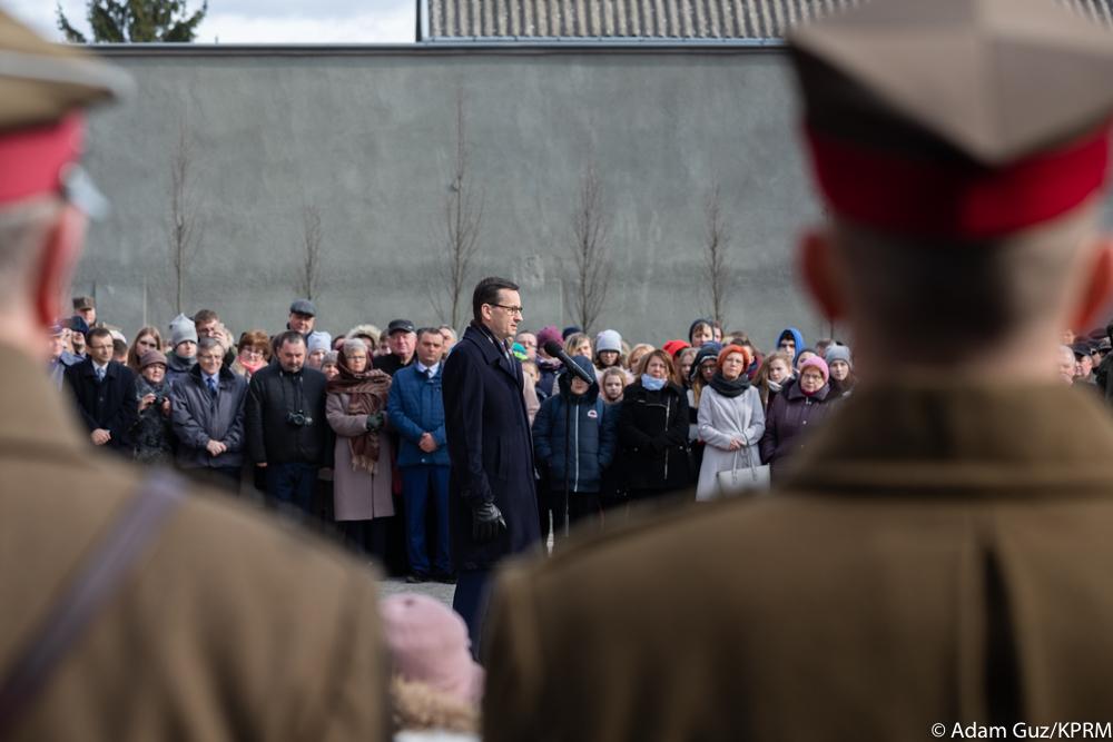 Premier Mateusz Morawiecki przemawia - przed nim żołnierze na pierwszym planie.