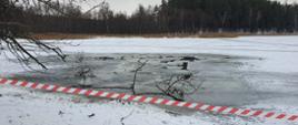 Jezioro zabezpieczone taśmą ostrzegawczą, na jeziorze załamane tafle lodu po akcji ratowniczej