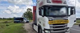 Na pierwszym planie (od prawej): przód ciągnika siodłowego z podpiętą naczepą do przewozu ładunków nienormatywnych. Zestaw stoi w zatoce kontrolnej przy drodze krajowej. W tle (od lewej): bok oznakowanego furgonu mazowieckiej Inspekcji Transportu Drogowego z otwartymi drzwiami do przestrzeni biurowo - kontrolnej.