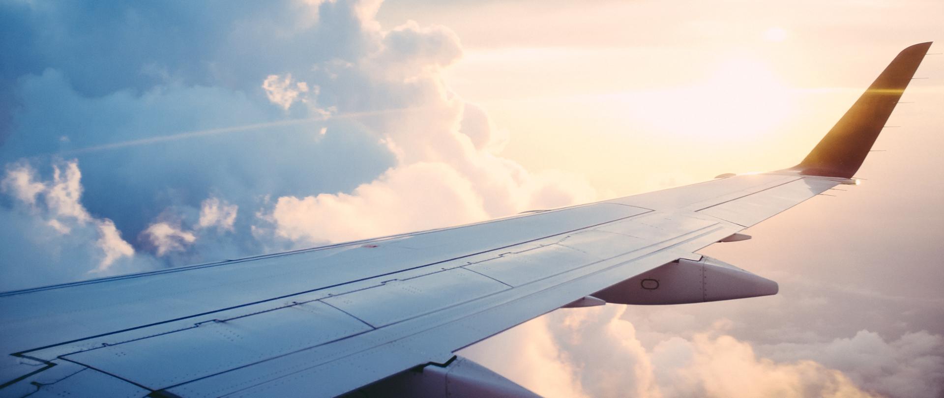 Na zdjęciu skrzydło samolotu lecącego w chmurach