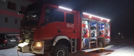 Samochód pożarniczy GCBA 5/40 na placu KP PSP w Starachowicach, pora nocna, oświetlenie boczne i otwarte skrytki ze sprzętem