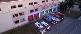 Na zdjęciu widoczni są funkcjonariusze na tle samochodów ratowniczo gaśniczych oraz ratownicy medyczni oddający hołd zmarłemu strażakowi Państwowej Straży Pożarnej