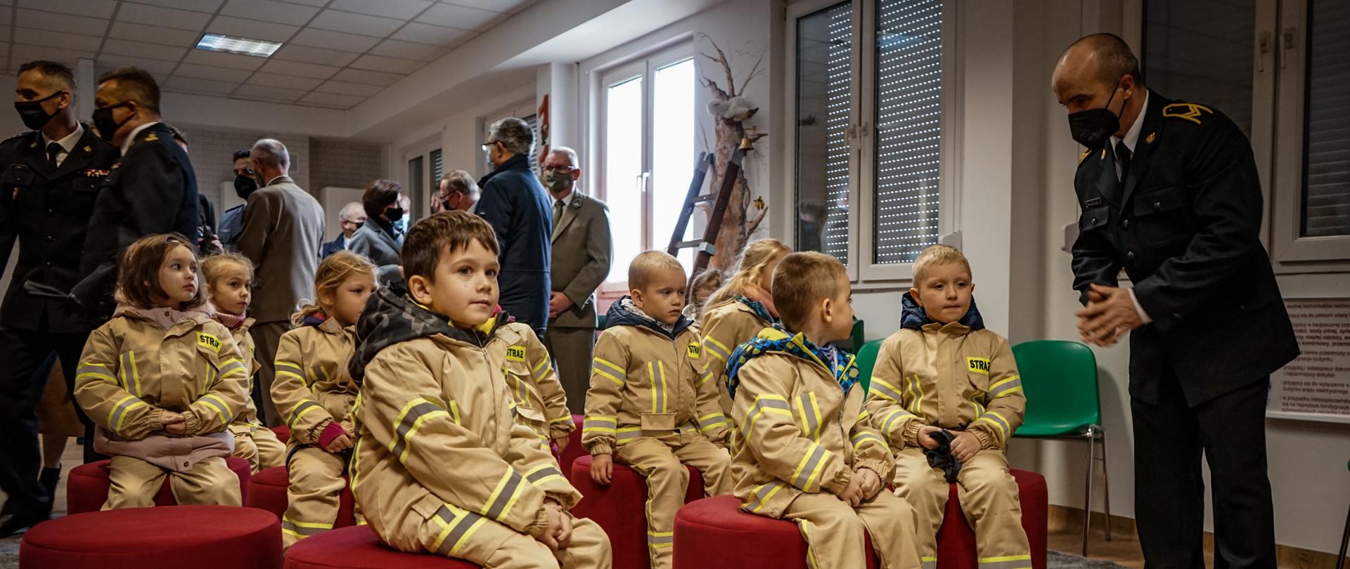 Na zdjęciu na pierwszym grupa przedszkolaków oraz strażak, na drugim planie osoby zaangażowane w powstanie salki edukacyjnej.