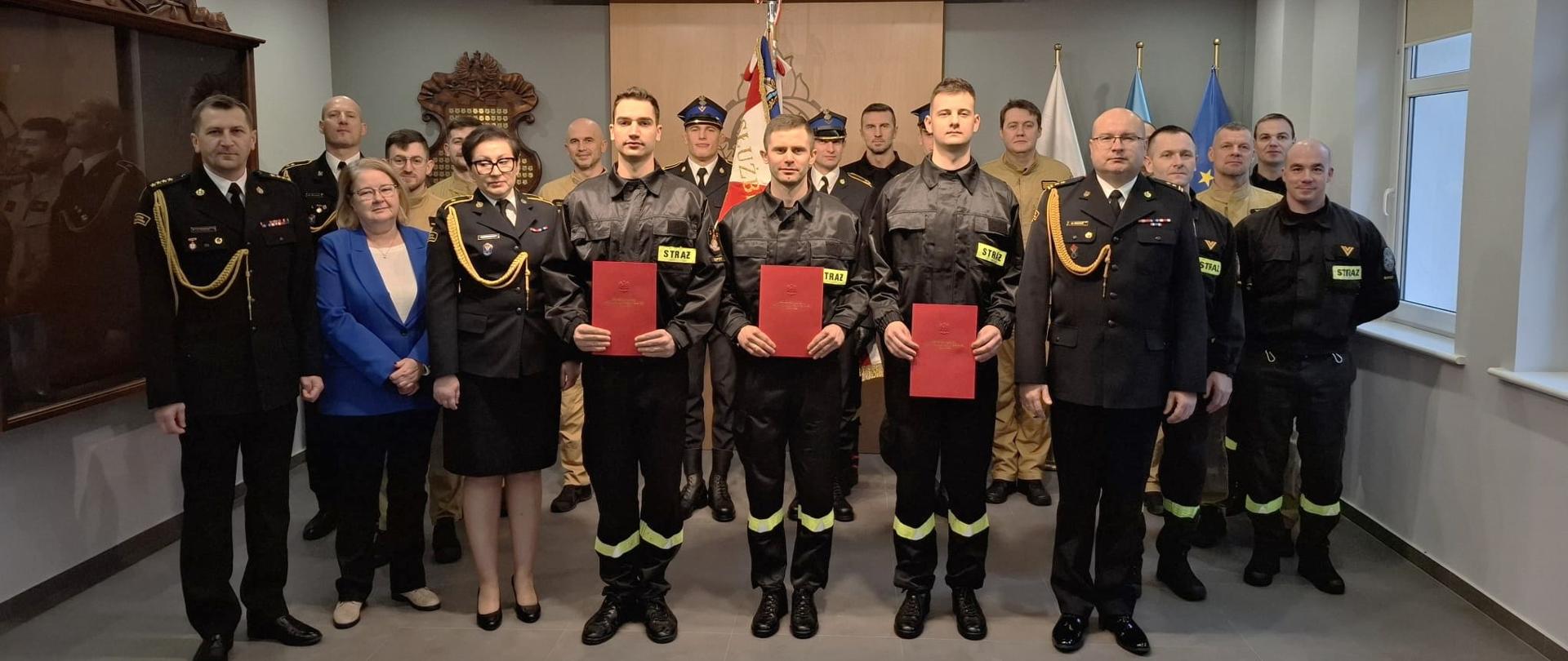 Na zdjęciu widać strażaków ubranych w mundury galowe oraz ubrania koszarowe oraz pracowników Komendy Miejskiej PSP w Sopocie. Grupowe zdjęcie pamiątkowe na zakończenie uroczystości.