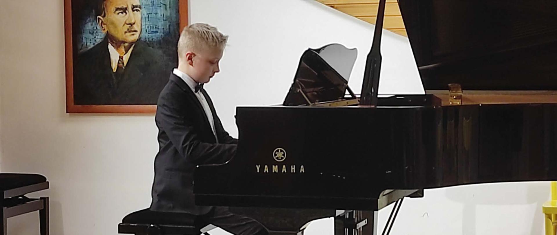 uczeń grający na fortepianie