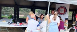 Ludzie przy stanowisku PSSE w Gdyni w trakcie Festynu Rodzinny Park Kioloński w dniu 08.06.2024