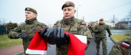 Żołnierz niosący flagę RP
