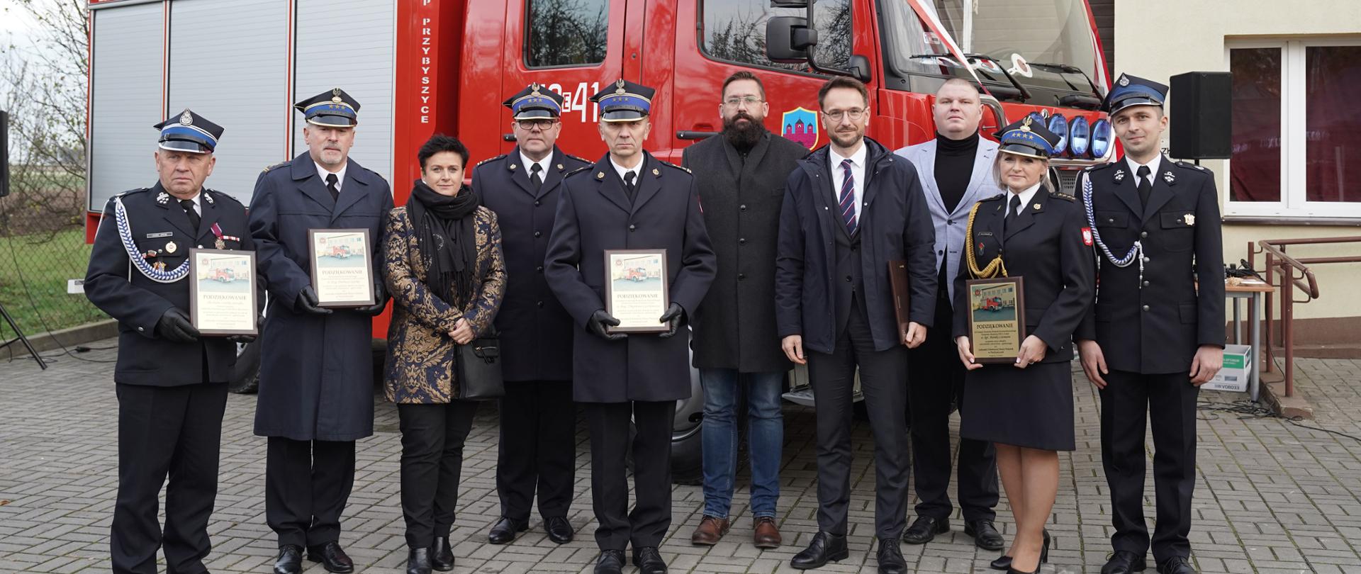 Na zdjęciu, na tle przekazanego samochodu znajdują się przedstawiciele strony rządowej, samorządowej oraz funkcjonariusze i druhowie