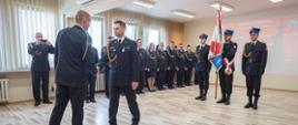 Na zdjęciu widoczny bryg. Przemysław Przęczek Zastępca Małopolskiego Komendanta Wojewódzkiego PSP, któremu bryg. Maciej Wolański składa meldunek o zdaniu obowiązków Zastępcy Komendanta Miejskiego PSP w Tarnowie. W tle widoczny poczet sztandarowy KM PSP w Tarnowie i funkcjonariusze tutejszej Komendy.