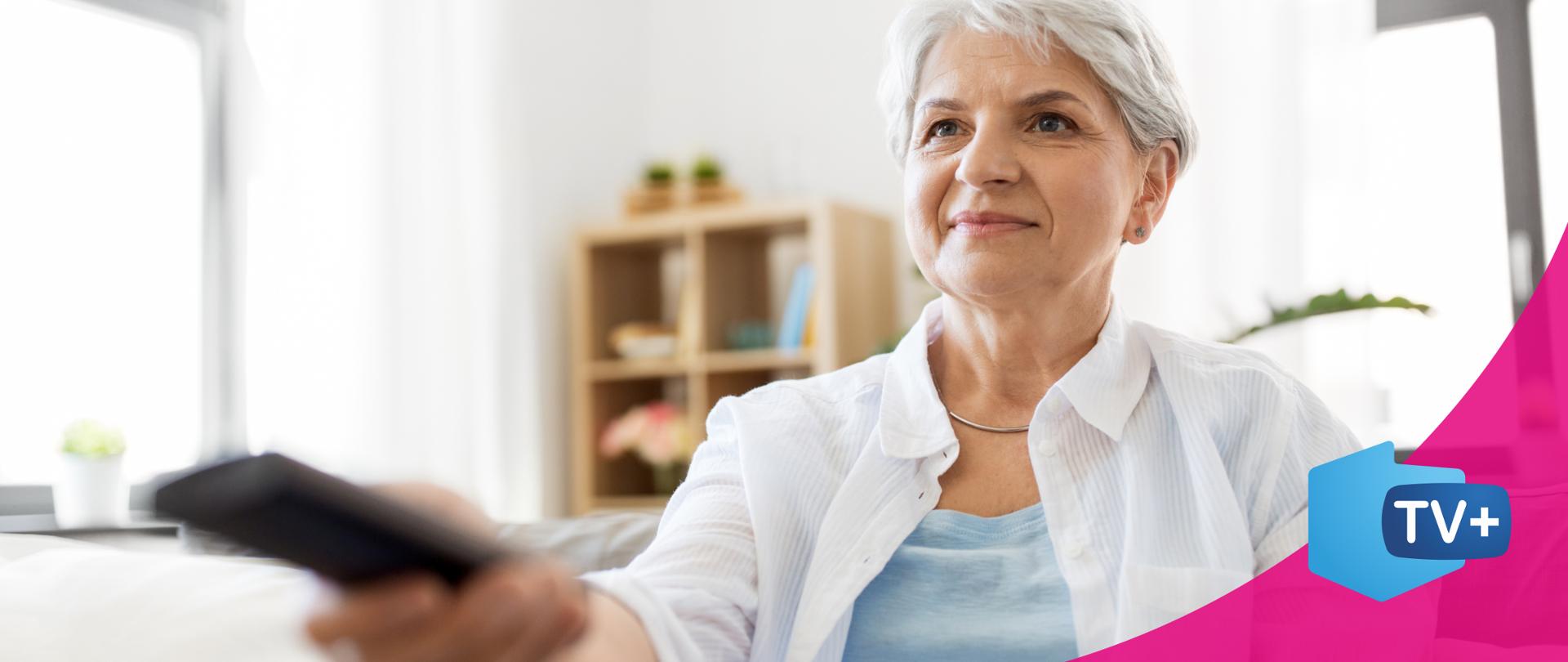 zdjęcie przedstawiające starszą kobietę trzymającą w ręku pilota od telewizora. 