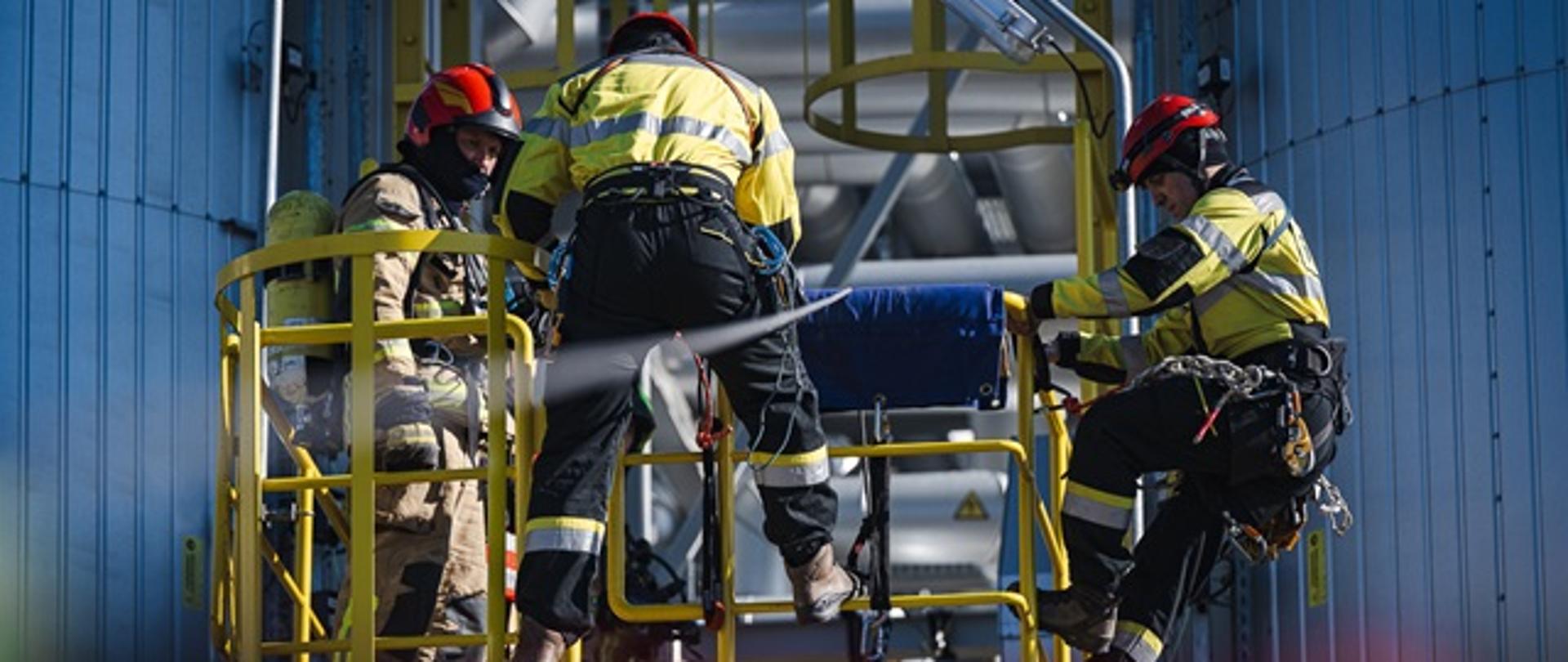 Na zdjęciu ratownicy wysokościowi przygotowujący się do ewakuacji poszkodowanego z wysokości przy użyciu technik linowych.