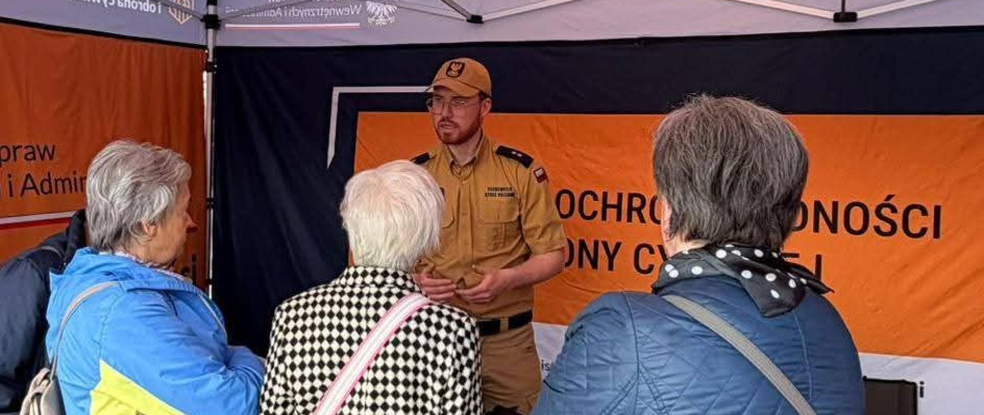 mł. kpt. Maciej Kuptz przestawia kobietom z klubu seniora podstawy bezpieczeństwa w sytuacjach zagrożenia.