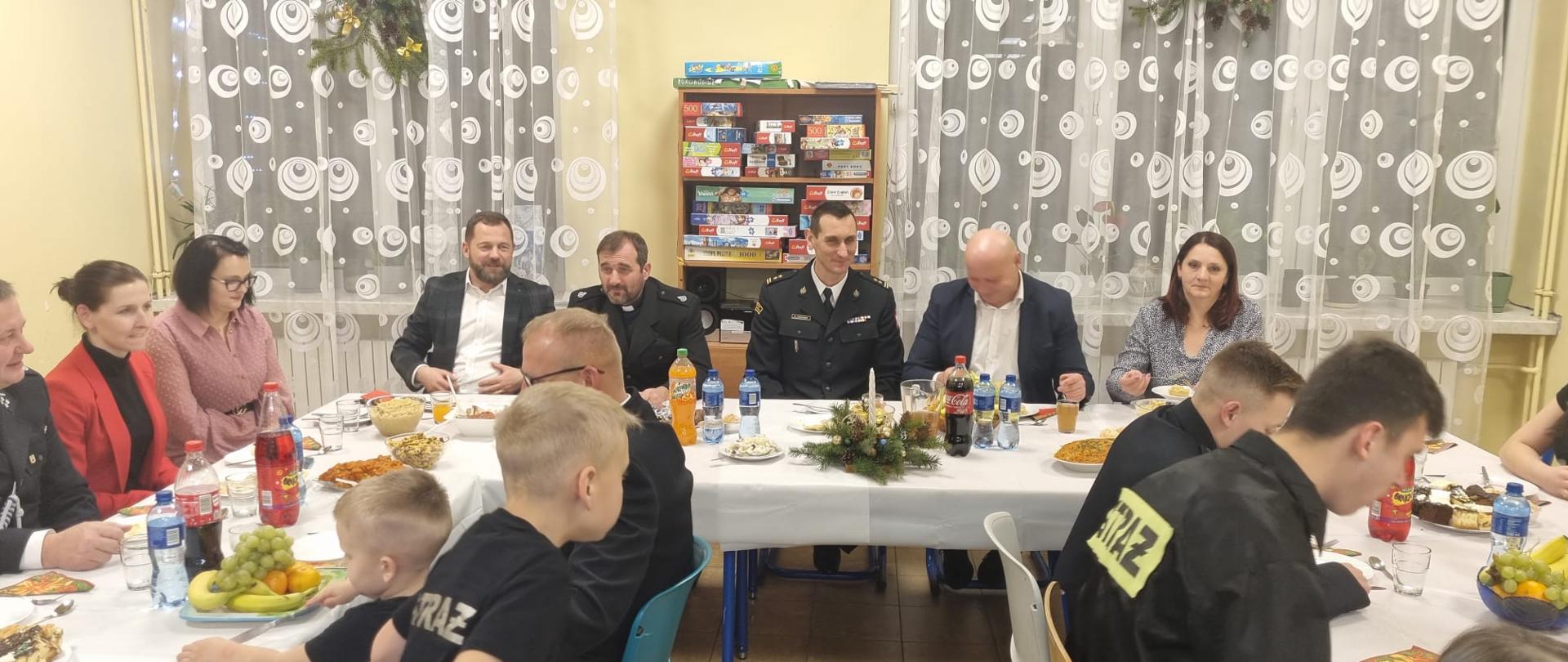 Zdjęcie przedstawia uczestników spotkania opłatkowego w siedzibie Jednostki Ochotniczej Straży Pożarnej w Kielcach.