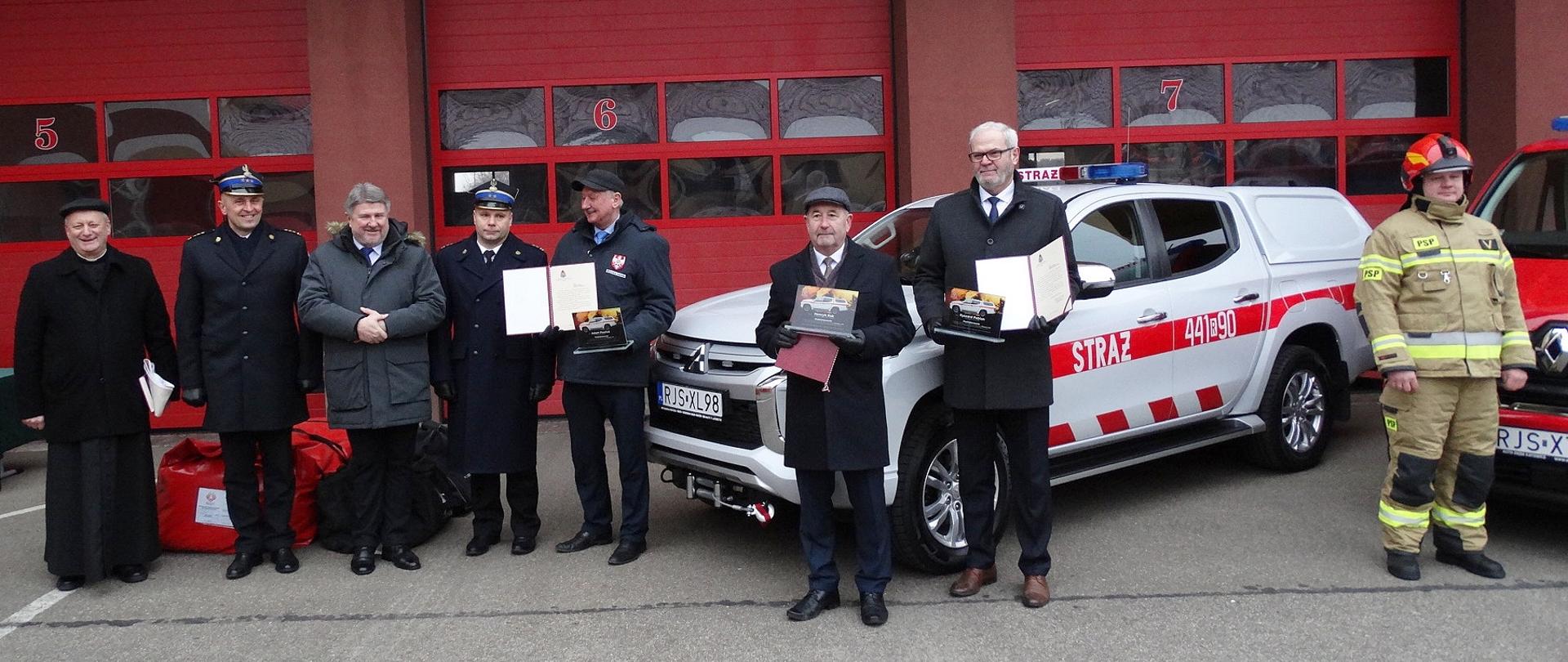 Na zdjęciu na tle nowych samochodów zaproszeni goście pierwszy od lewej : ksiądz Zbigniew Irzyk dziekan Dekanatu Jasło Wschód,starszy brygadier Daniel Dryniak zastępca podkarpackiego komendanta wojewódzkiego , Bogdan Rzońca Poseł do Parlamentu Europejskiego, brygadier Piotr Śmietana, Adam Pawluś starosta jasielski,, Henryk Rak przewodniczący Rady Miasta Jasła, Ryszard Pabian burmistrz Miasta Jasła