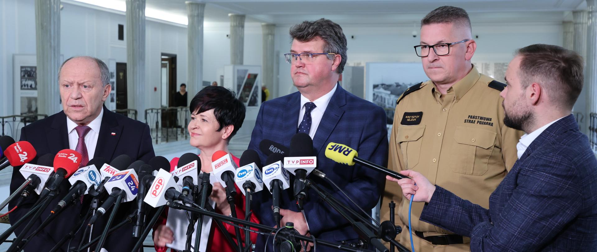 Konferencja prasowa w sejmie. Wiceminister Maciej Wąsik, przewodniczący Parlamentarnego Zespołu Strażaków Zbigniew Chmielowiec, poseł Joanna Borowiak oraz zastępca komendanta głównego PSP nadbryg. Krzysztof Hejduk udzielają odpowiedzi na pytania od reporterów.