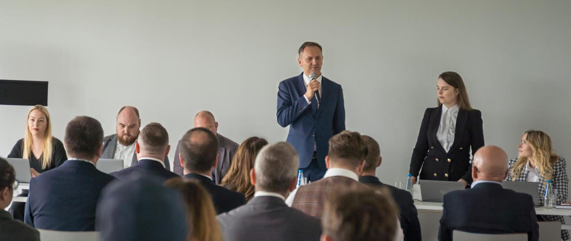 Przedstawiciele Ministerstwa Cyfryzacji prowadzący spotkanie inauguracyjne ICT. Wiceminister Rafał Rosiński przemawia. 