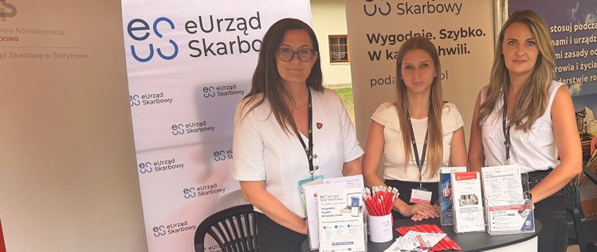Pani Naczelnik US w Strzyżowie i dwie ekspertki stoją przy stanowisku podkarpackiej KAS.