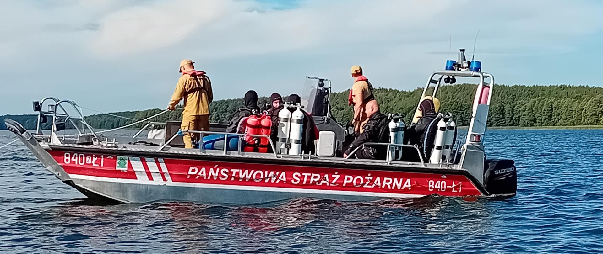 Na zdjęciu widać lódź na wodzie z napisem Państwowa Straż Pożarna oraz grupą strażaków na pokładzie.
