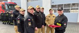 Na zdjęciu funkcjonariusz odchodzący na zaopatrzenie emerytalne wraz z Dowódcą JRG, Dowódcą zmiany II oraz czterema funkcjonariuszami JRG