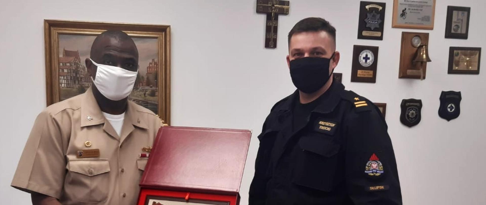 Zdjęcie przedstawia Komendanta miejskiego PSP w Słupsku oraz dowódcę bazy wojskowej w Redzikowie trzymającego pamiątek w formie zdjęcia Komendy.