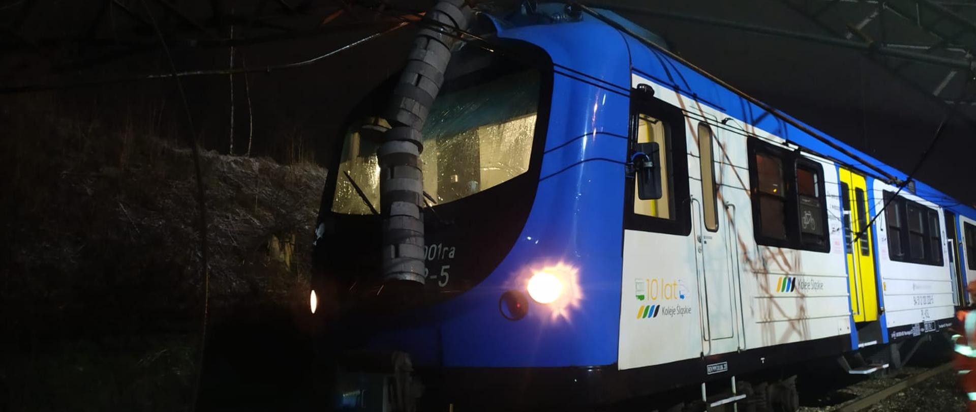 Zdjęcie przedstawia lokomotywę pociągu, który uderzył w przewróconą bramkę trakcyjną 