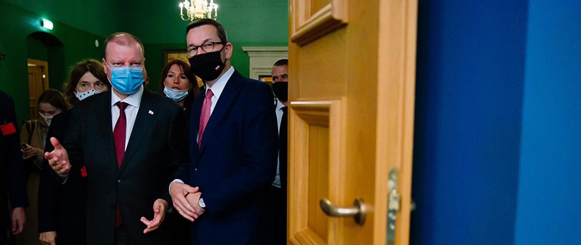 Premierzy Polski i Litwy wchodzą przez drzwi.
