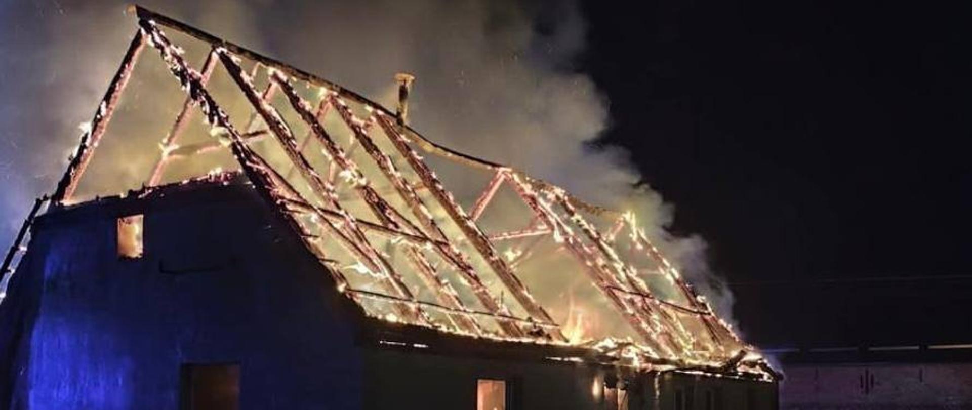 Zdjęcie przedstawia palący się dom.