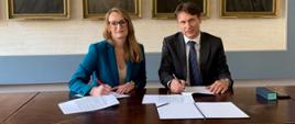 Za stołem siedzą Aneta Korczyc, dyrektor ZUOP i dr hab. inż. Maciej Chaczykowski, prof. PW, dziekan Wydziału Inżynierii Środowiska i podpisują porozumienie o współpracy. 