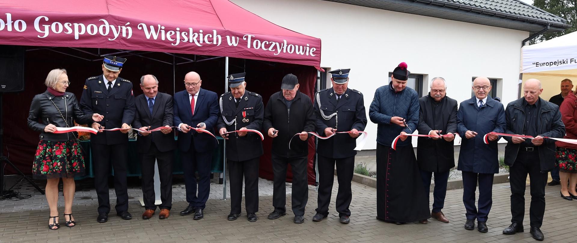 Uczestnicy uroczystości przecinają wstęgę