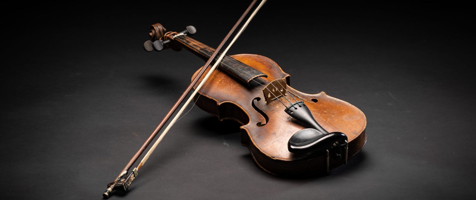 Zdjęcie skrzypiec ze smyczkiem na czarnym tle