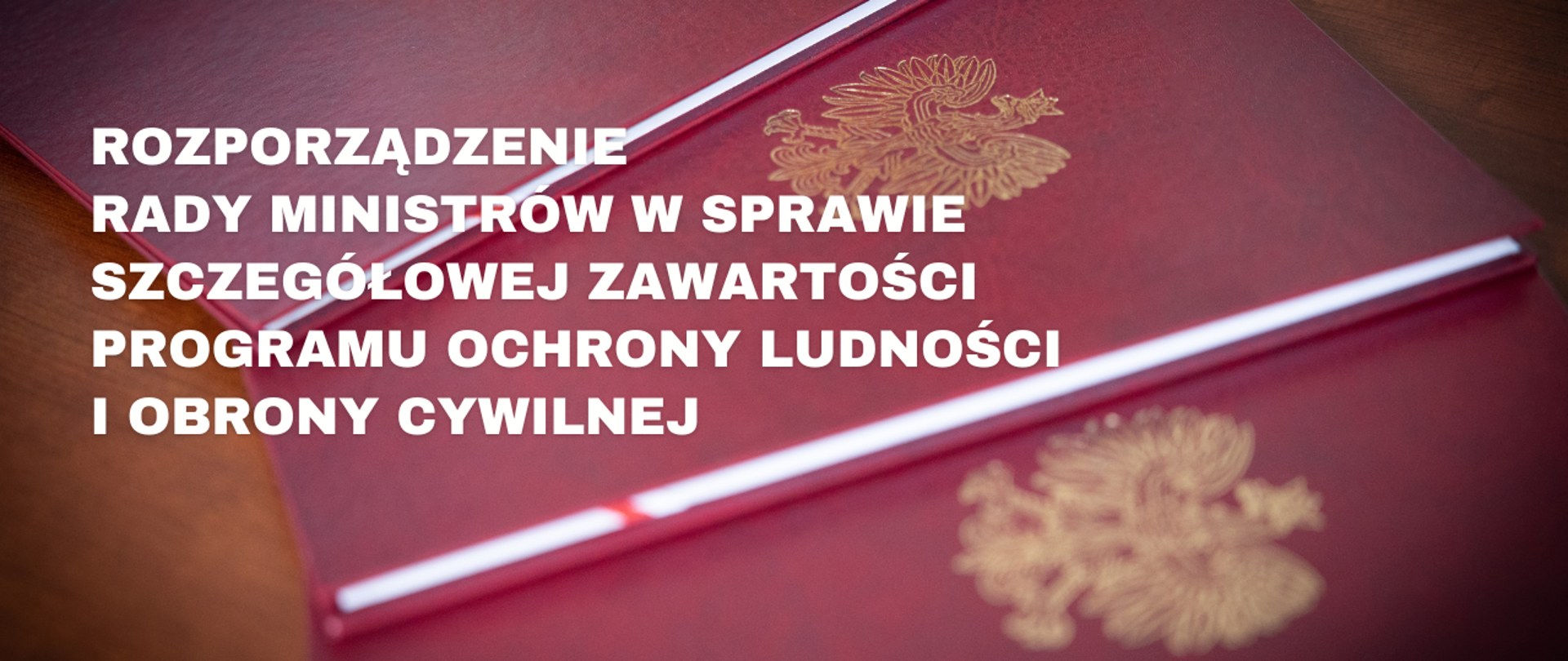 Grafika informacyjna. Zdjęcie czerwonych teczek z orłem i napis: Rozporządzenie Rady Ministrów w sprawie szczegółowej zawartości Programu Ochrony Ludności i Obrony Cywilnej