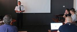 Na zdjęciu Zastępca Komendanta Centralnej Szkoły PSP, zwrócony do uczestników, przemawia otwierając obrady