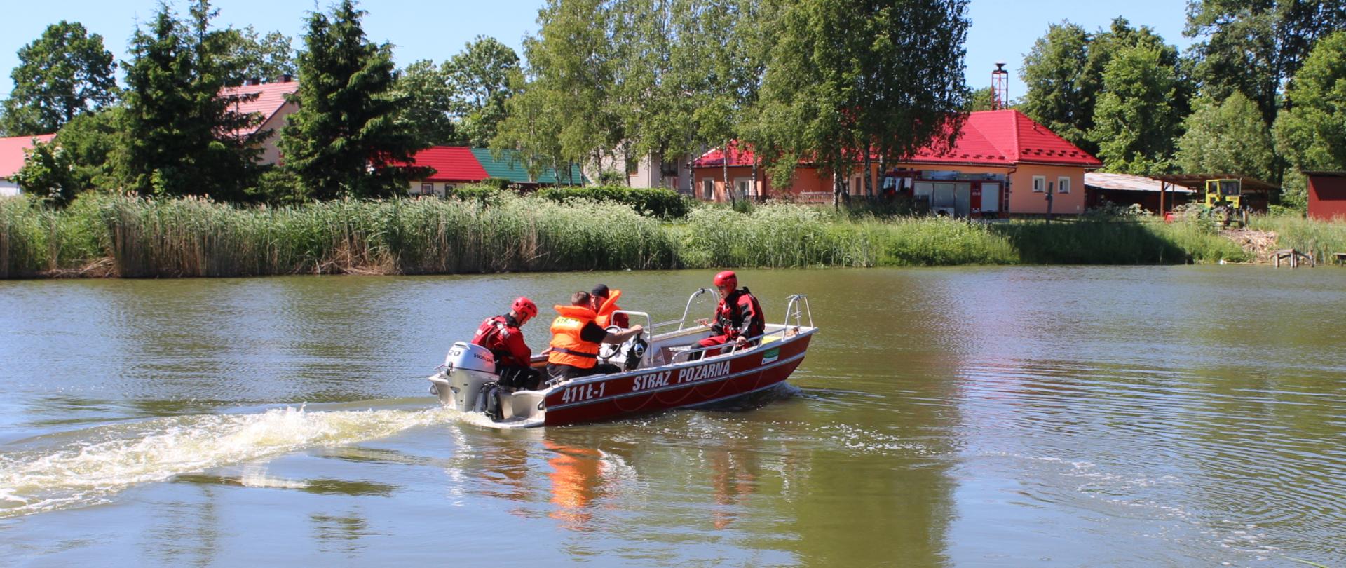 ratownicy podczas poruszania się łodzią ratunkową po zbiorniku wodnym 