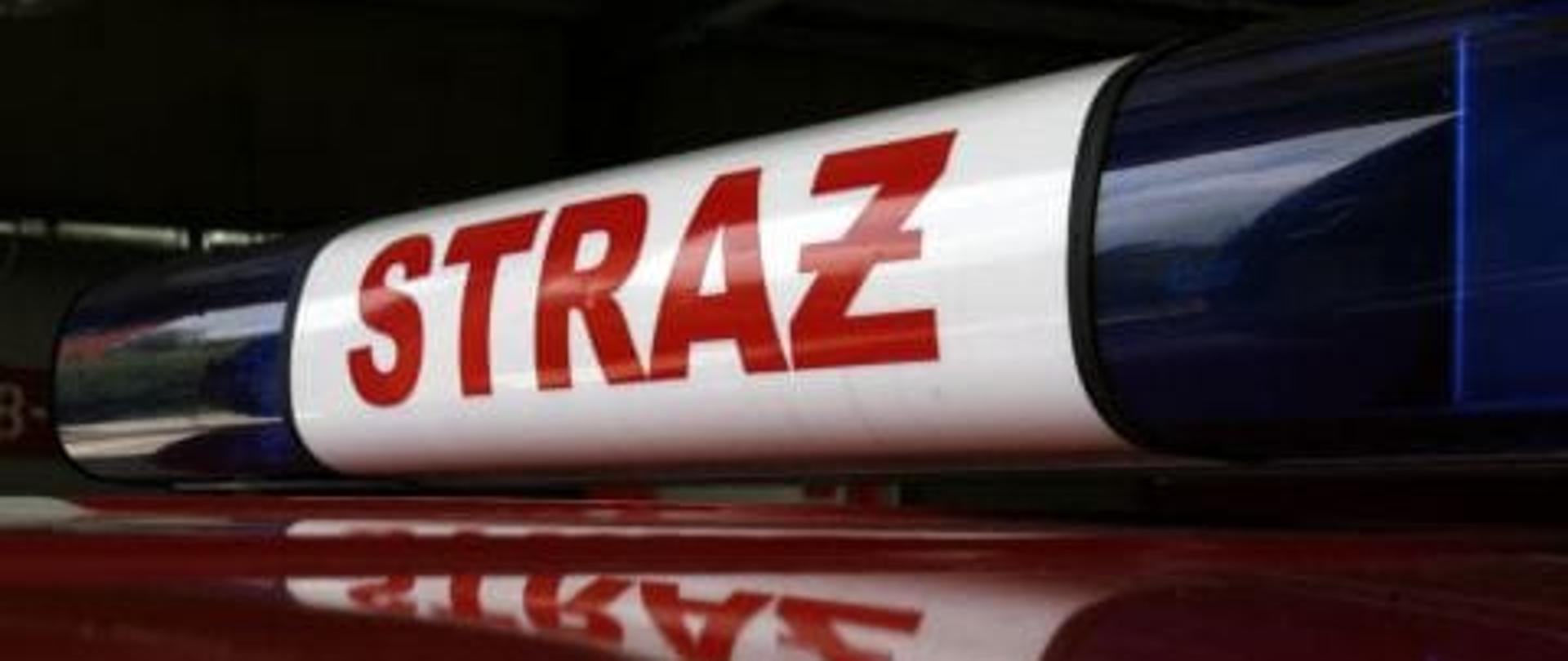 Dach samochodu straży pożarnej z sygnalizacją świetlna. W tle garaż JRG.