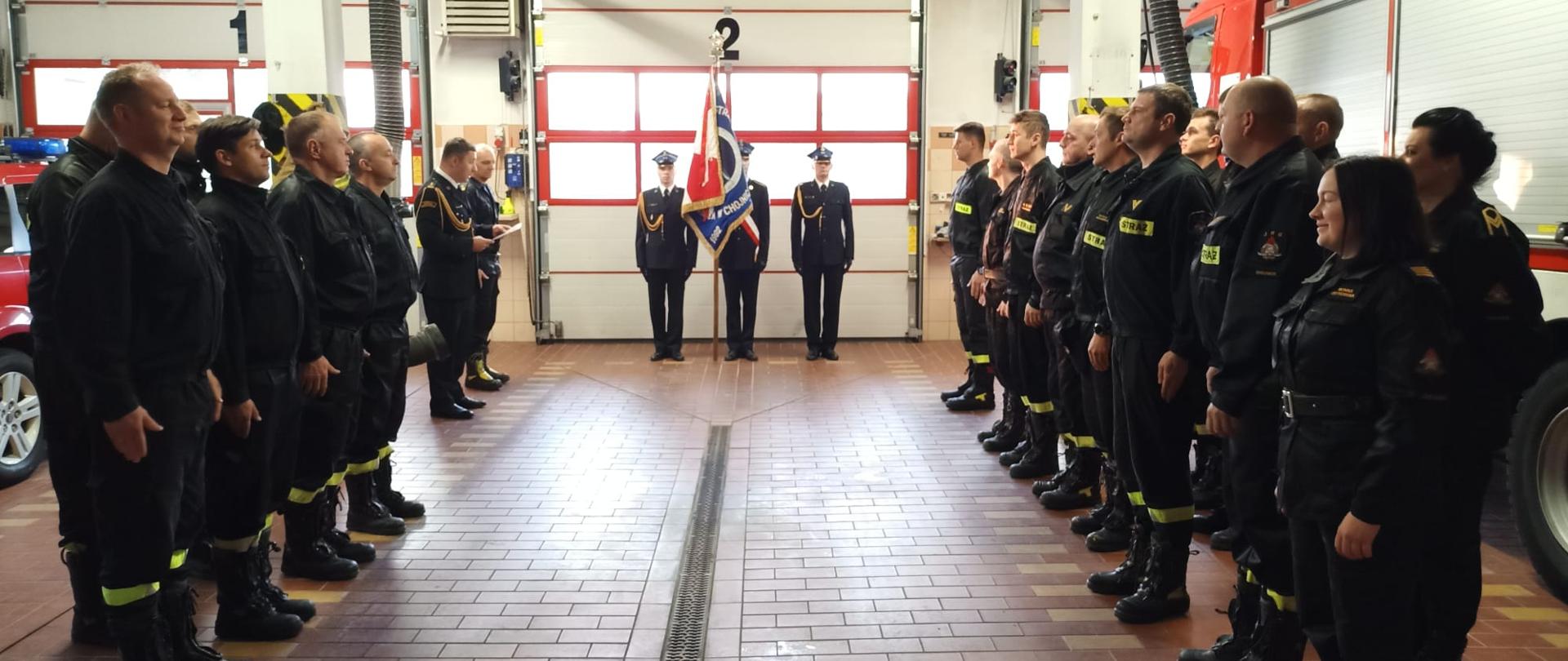 Po lewej i prawej stronie zdjęcia pododdziały strażaków. W tle poczet sztandarowy. Przygotowanie do ślubowania.
