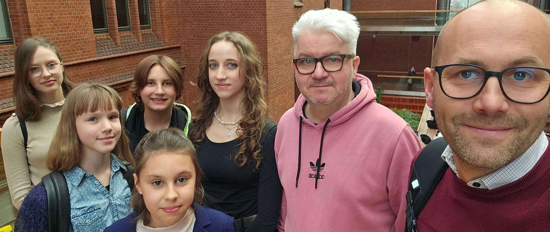 Grupa uczennic wraz z nauczycielami na patio Akademii Muzycznej w Katowicach