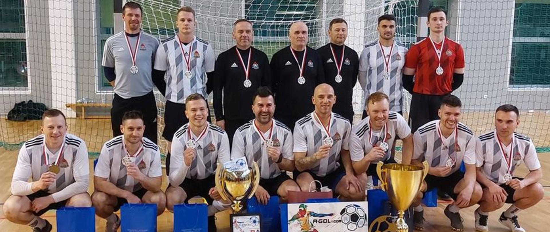 drużyna piłkarzy pozuje do zdjęcia w sali sportowej