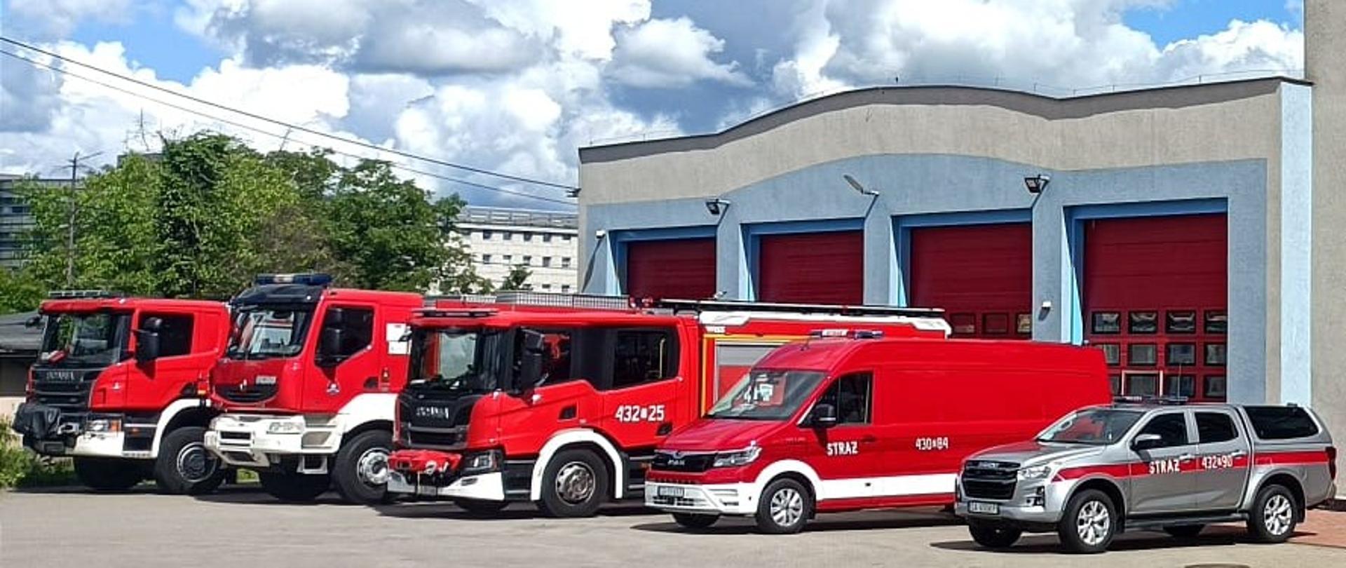 Czerwone samochody pożarnicze stojące przed garażami oraz jednostka ratowniczo gaśniczą numer 3 w Gdyni.